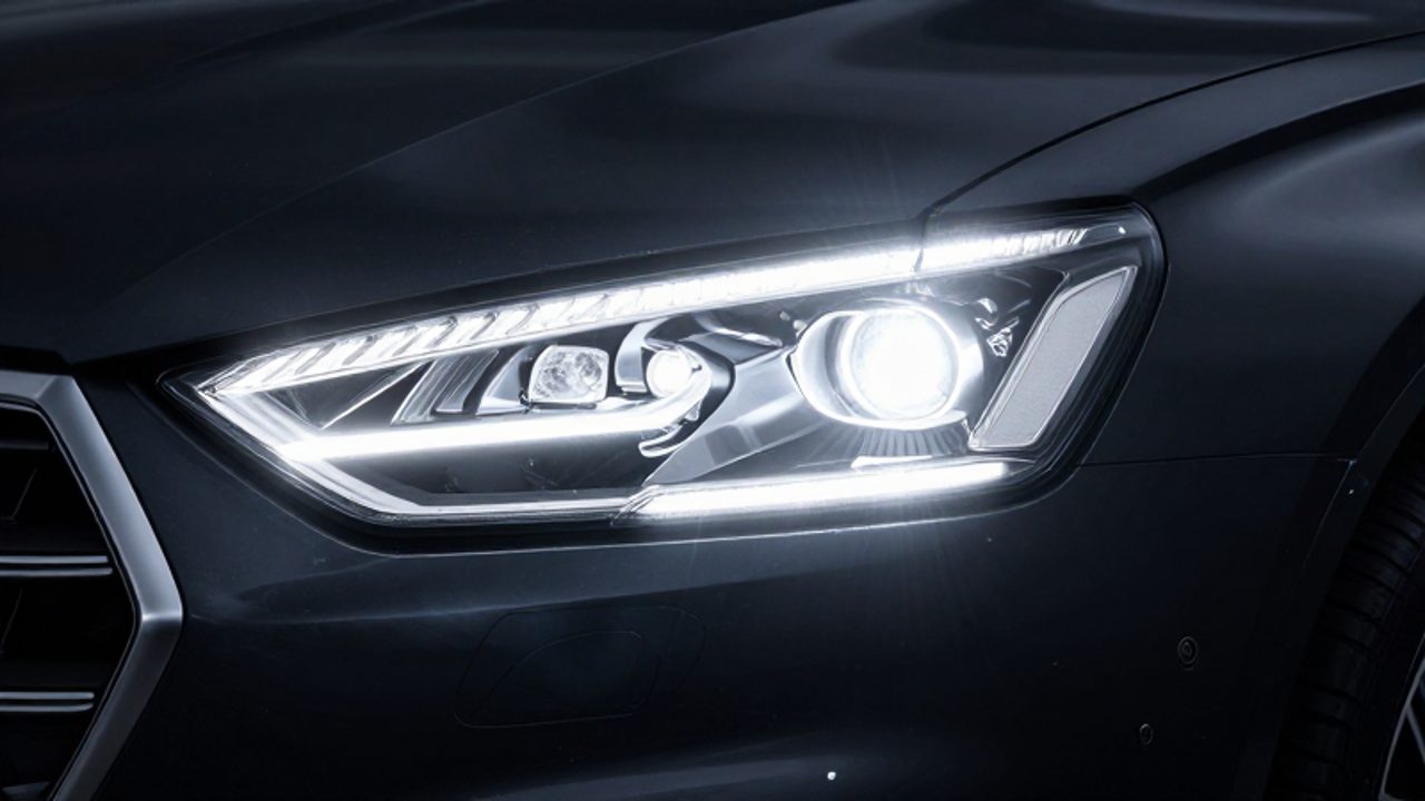 Primer plano de un faro de coche moderno iluminando con una luz blanca intensa y nítida desde su interior tecnológico.